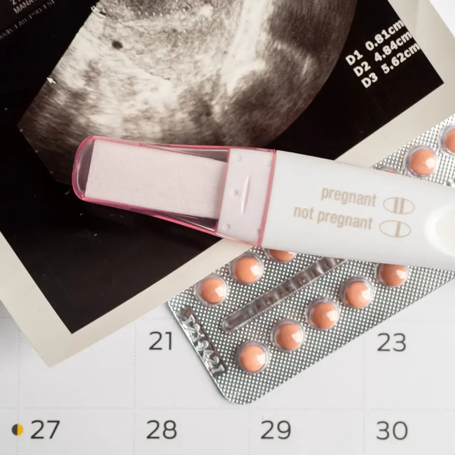 Pregnancy test and birth control pills with ultrasound scan of baby uterus, contraception health and medicine.