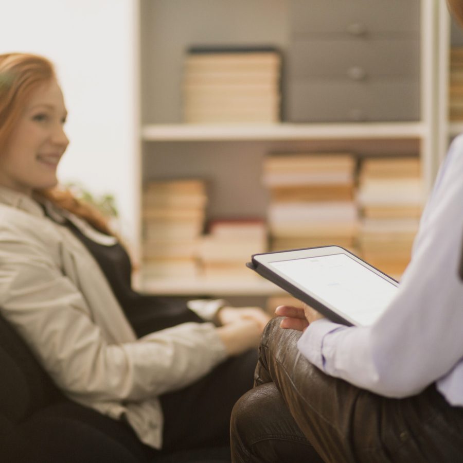 Woman sitting in a chair and talking to a therapist during psychotherapy